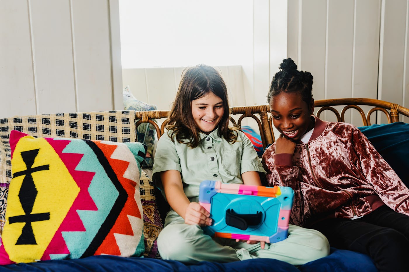 Two young girls use a tablet together