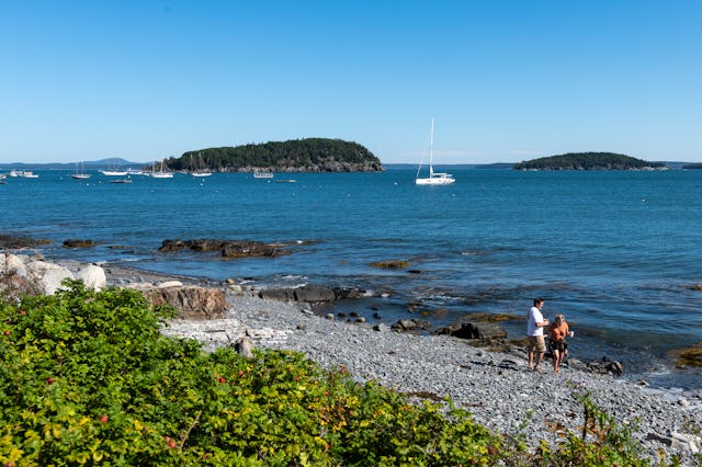 Bar Harbor, ME - September 17: Two people walk along Bar Harbor Town Beach on a sunny weekend mornin...