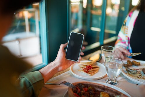 Mobile phone screen with dining table in a restaurant.