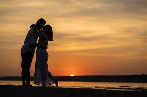 Silhouette of couple in love at the sunset with copy space