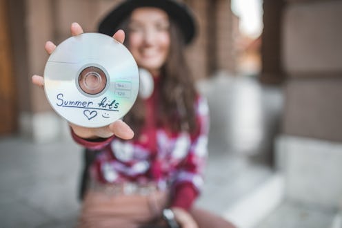 A young woman is enjoying a beautiful day while listening to music with a disc player