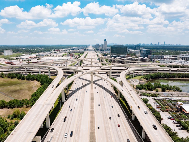 Drone point of view of traffic on the interstate, intertwining on ramps and off ramps.