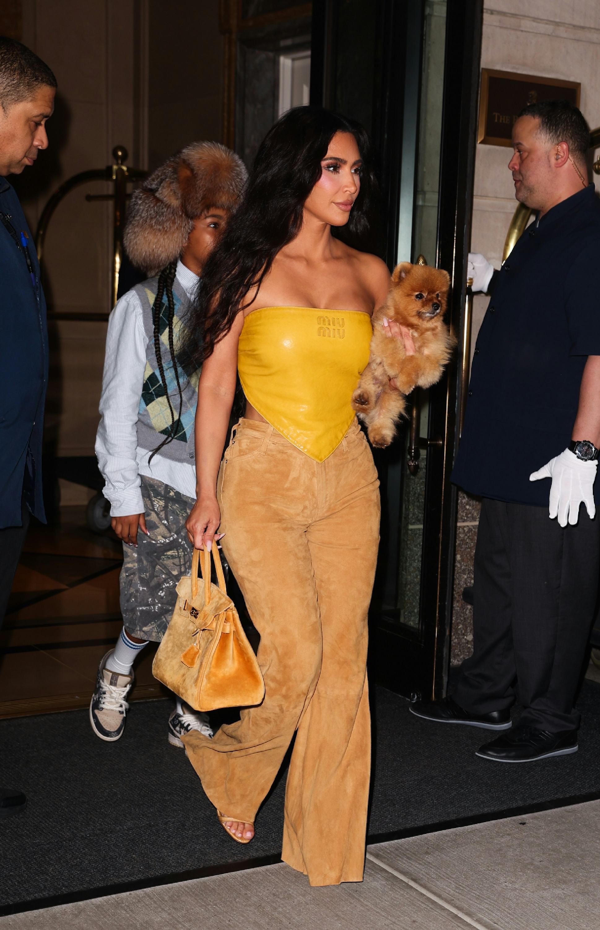 Kim Kardashian wears a mustard leather bandana top on August 14, 2024 in New York, New York.