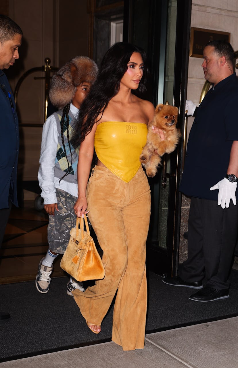 Kim Kardashian wears a mustard leather bandana top on August 14, 2024 in New York, New York.
