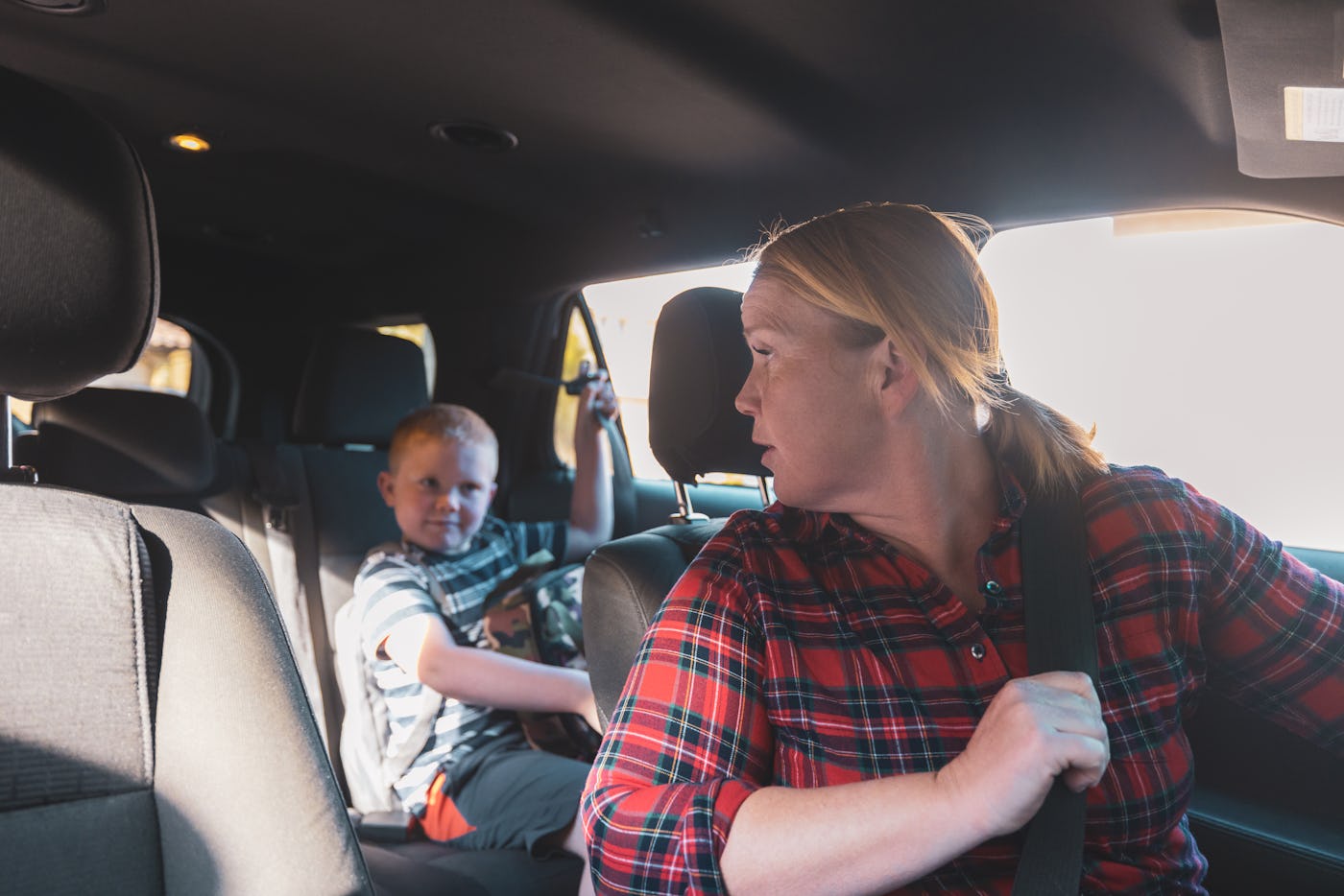 A mom in the car line dropping her kid off at school. She's frustrated.