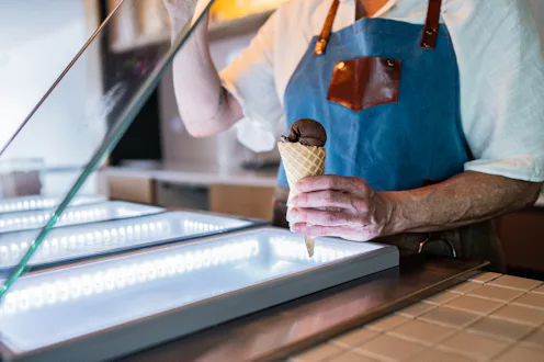Close-up of a ice cream seller preparing ice cream at ice cream shop