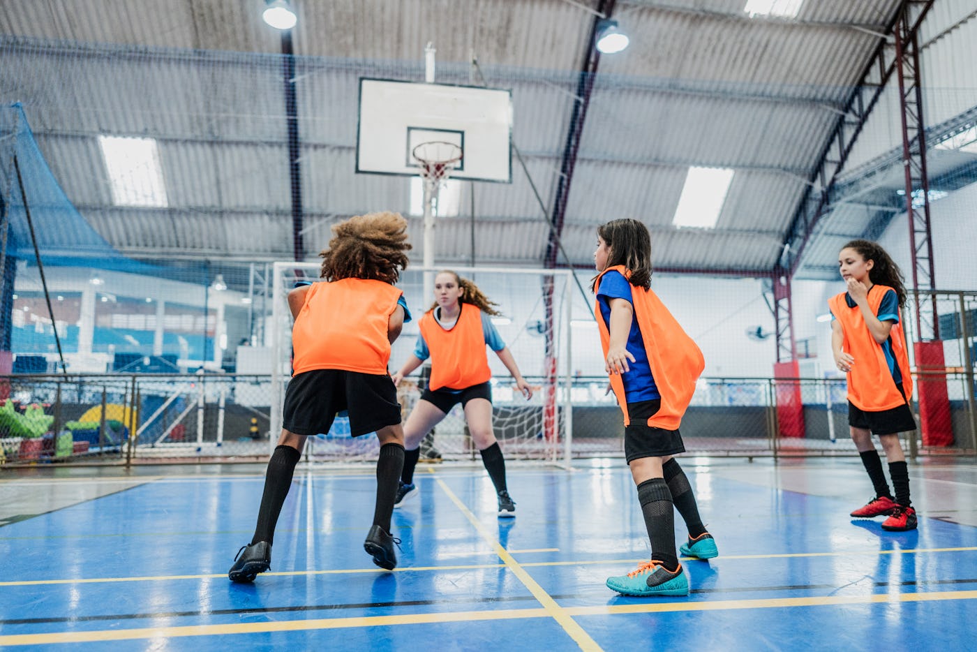 Children playing basketball at a sports court