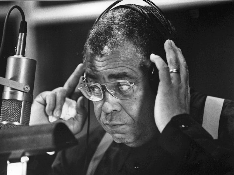 Close-up of American actor James Earl Jones as he adjust his headphones, behind a microphone in a re...