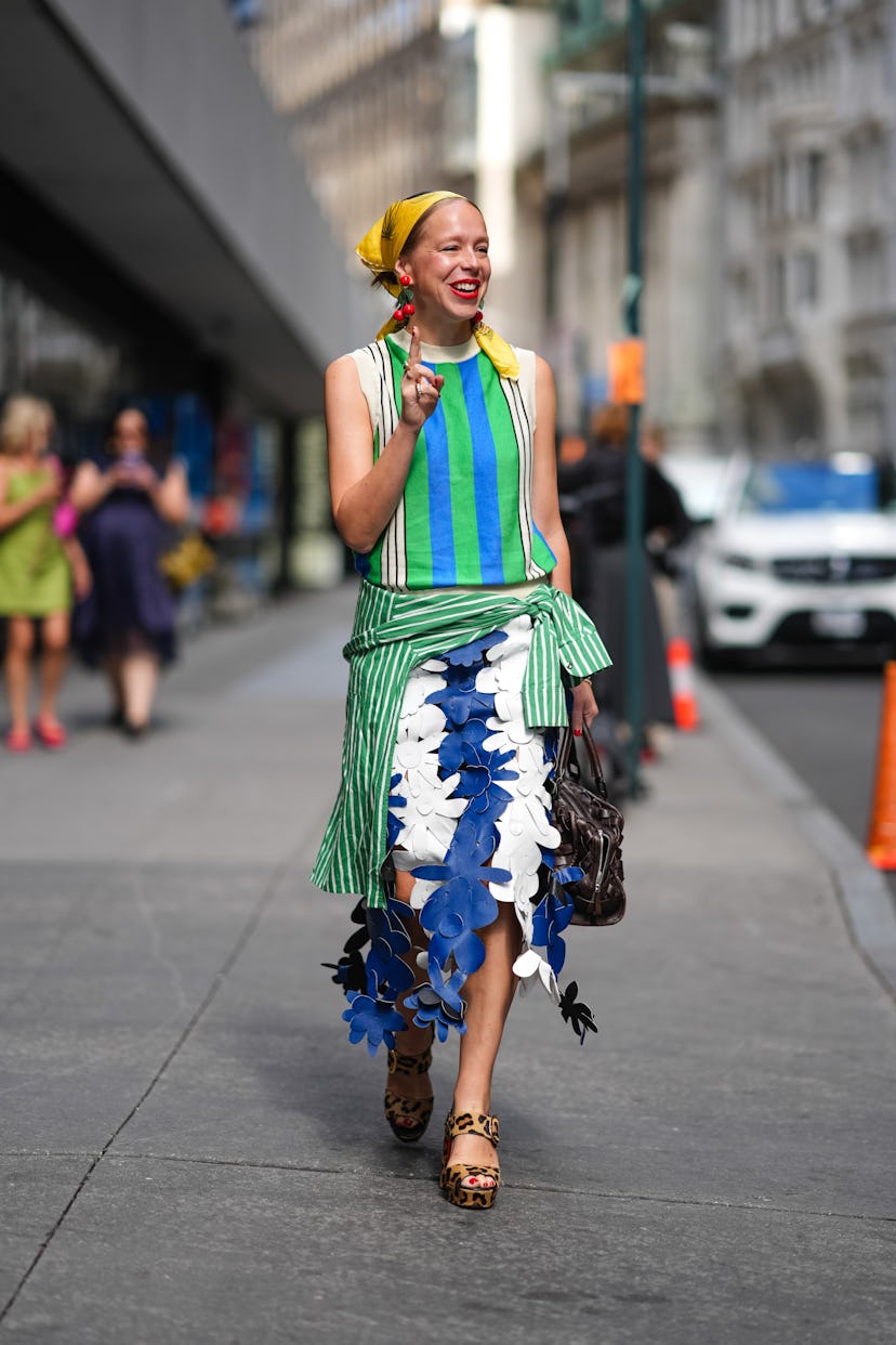 NEW YORK, NEW YORK - SEPTEMBER 09: A guest wears light yellow head scarf, bright red cherry earrings...