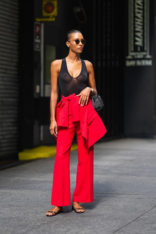 NEW YORK, NEW YORK - SEPTEMBER 09: A guest wears black sunglasses, black sheer mesh halter top, brig…