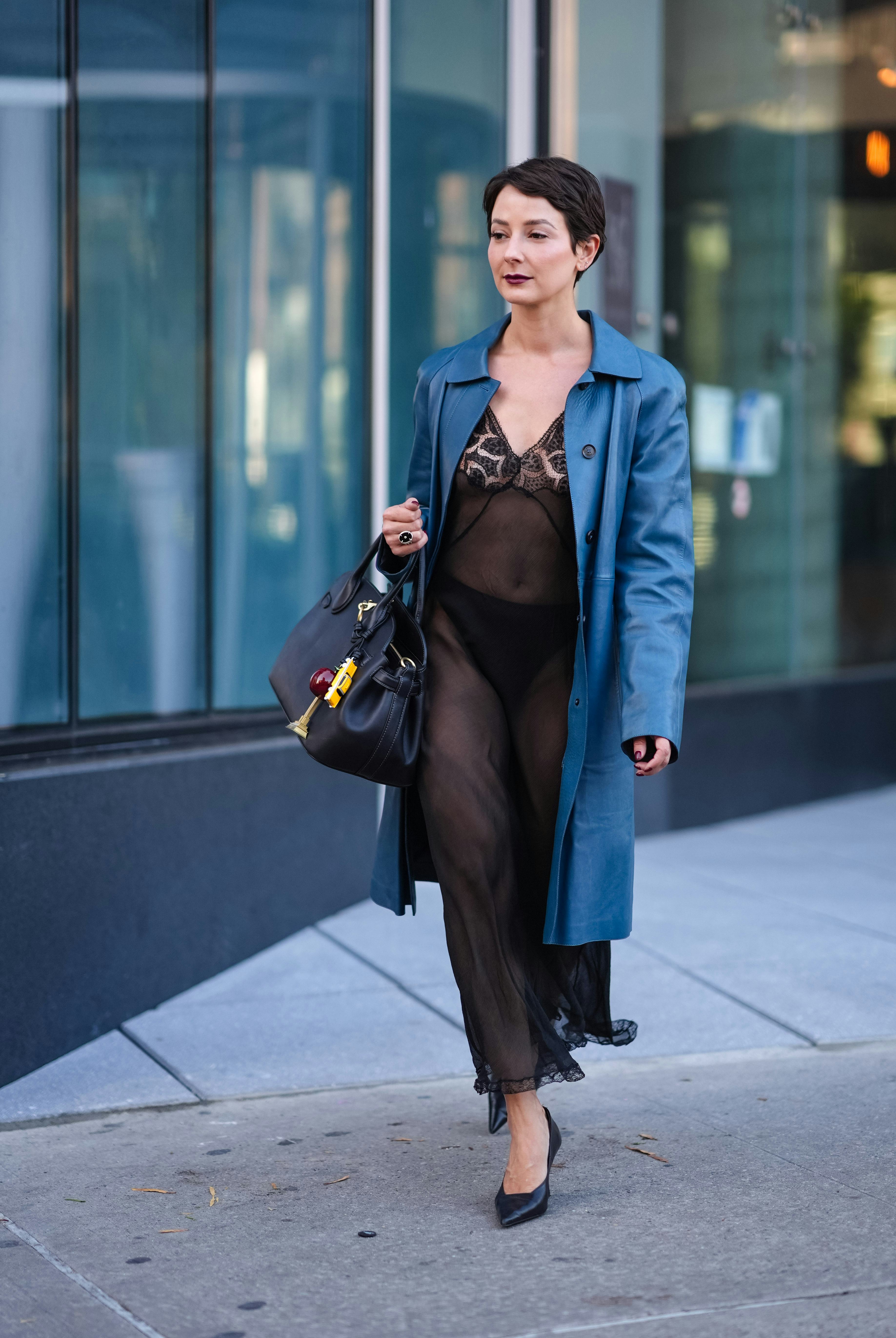 NEW YORK, NEW YORK - SEPTEMBER 09: Alyssa Coscarelli wears shiny dark blue trench coat, black sheer &hellip;