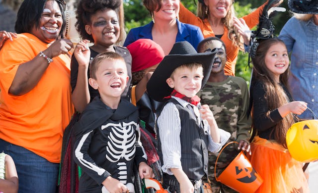 A group of women and children wearing halloween costumes, standing outdoors. Boston has introduced S...