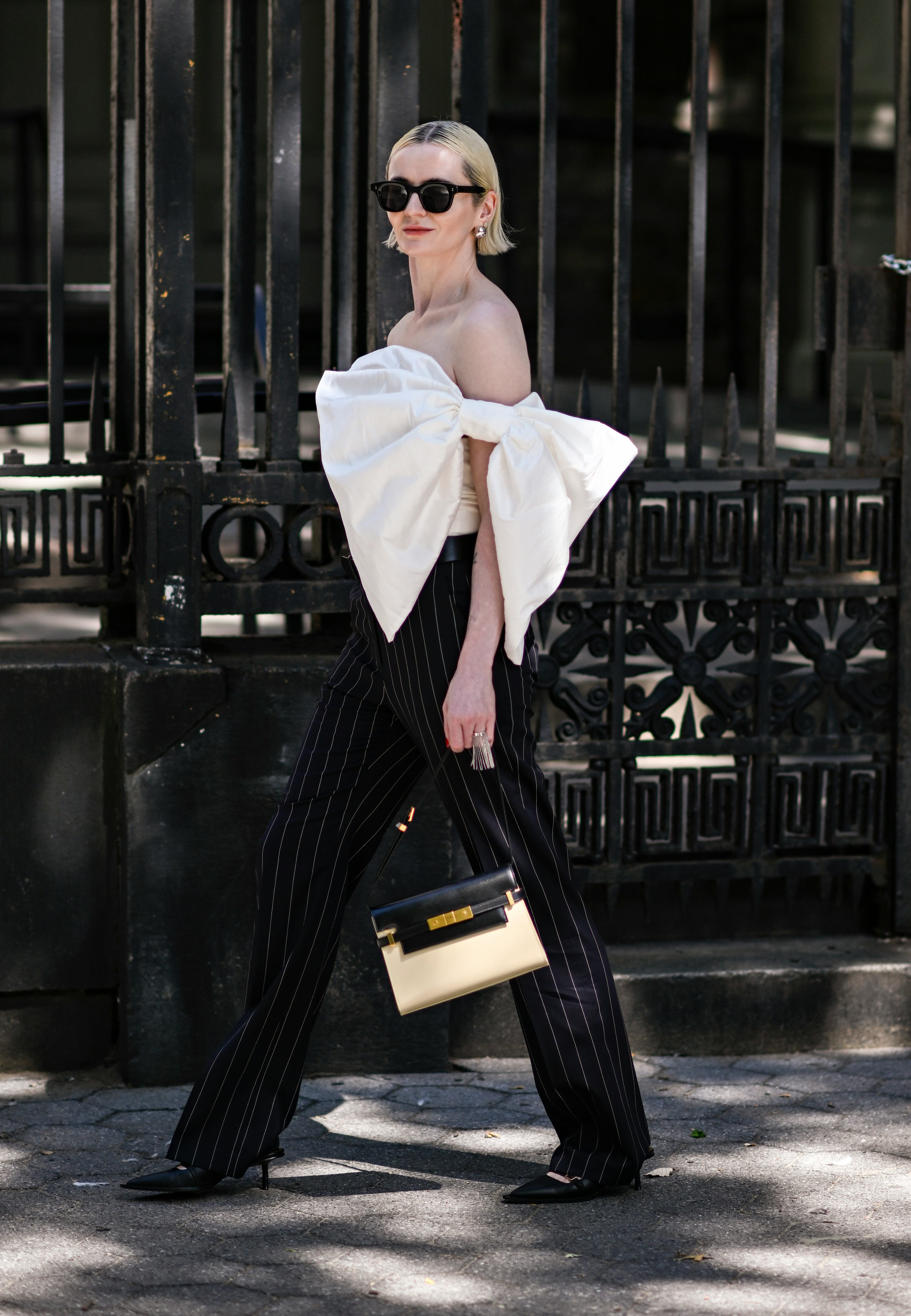NEW YORK, NEW YORK - SEPTEMBER 11: A guest is seen wearing a white bow top, black pinstripe pants an&hellip;