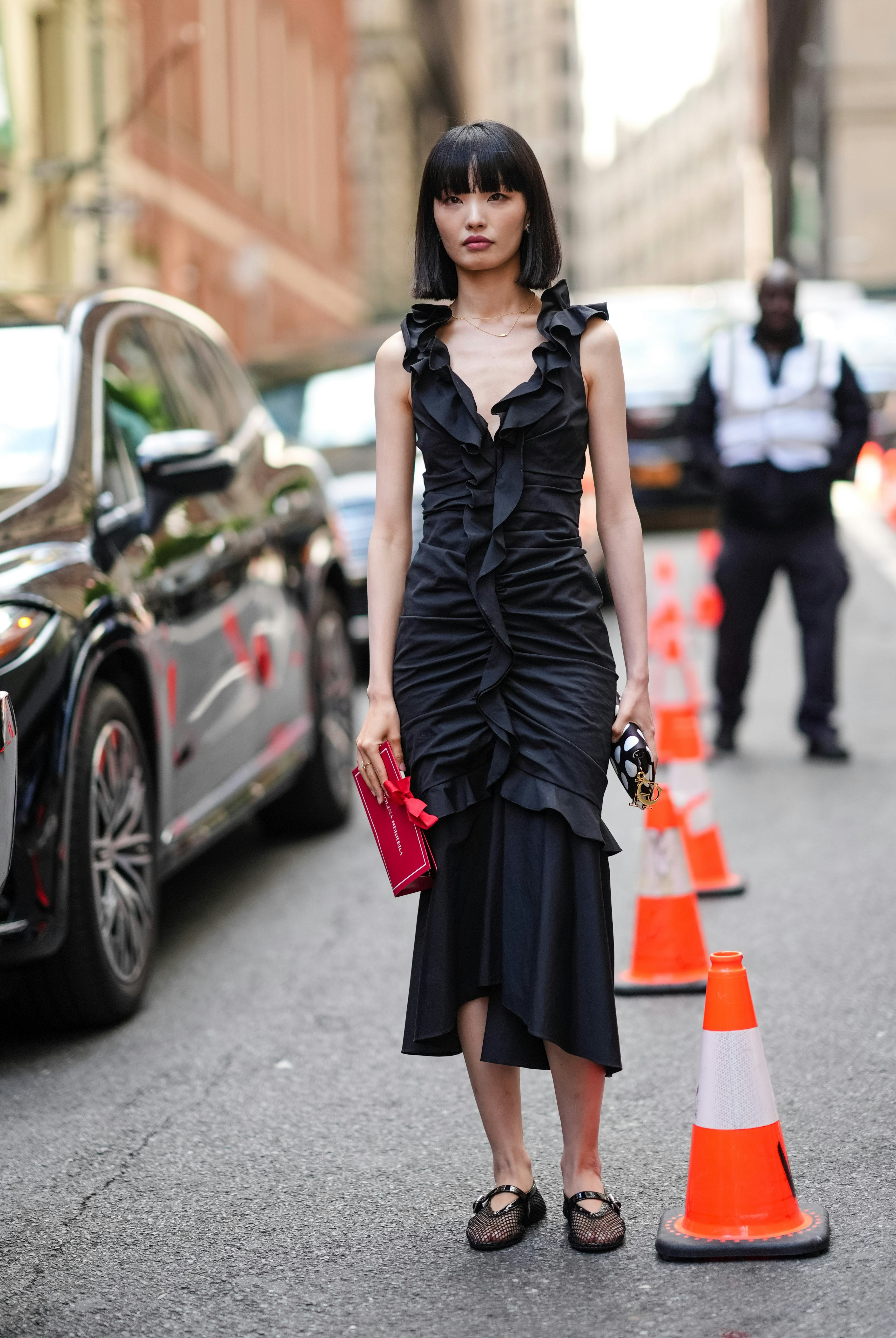 NEW YORK, NEW YORK - SEPTEMBER 09: A guest wears silver earrings, black ruffled sleeveless Carolina &hellip;