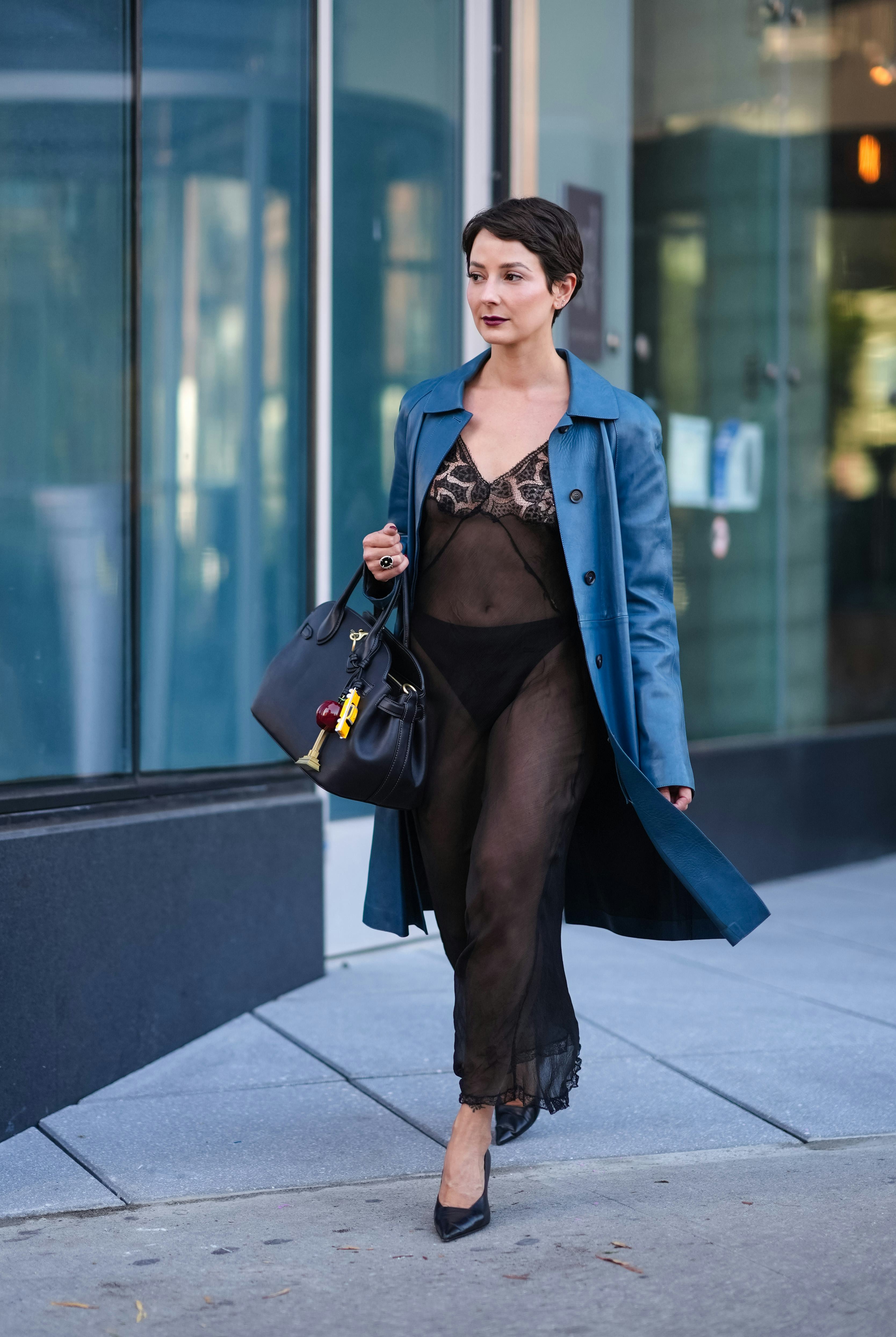 NEW YORK, NEW YORK - SEPTEMBER 09: Alyssa Coscarelli wears shiny dark blue trench coat, black sheer &hellip;