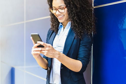 Young woman in jacket and shirt smiling and chatting on the phone