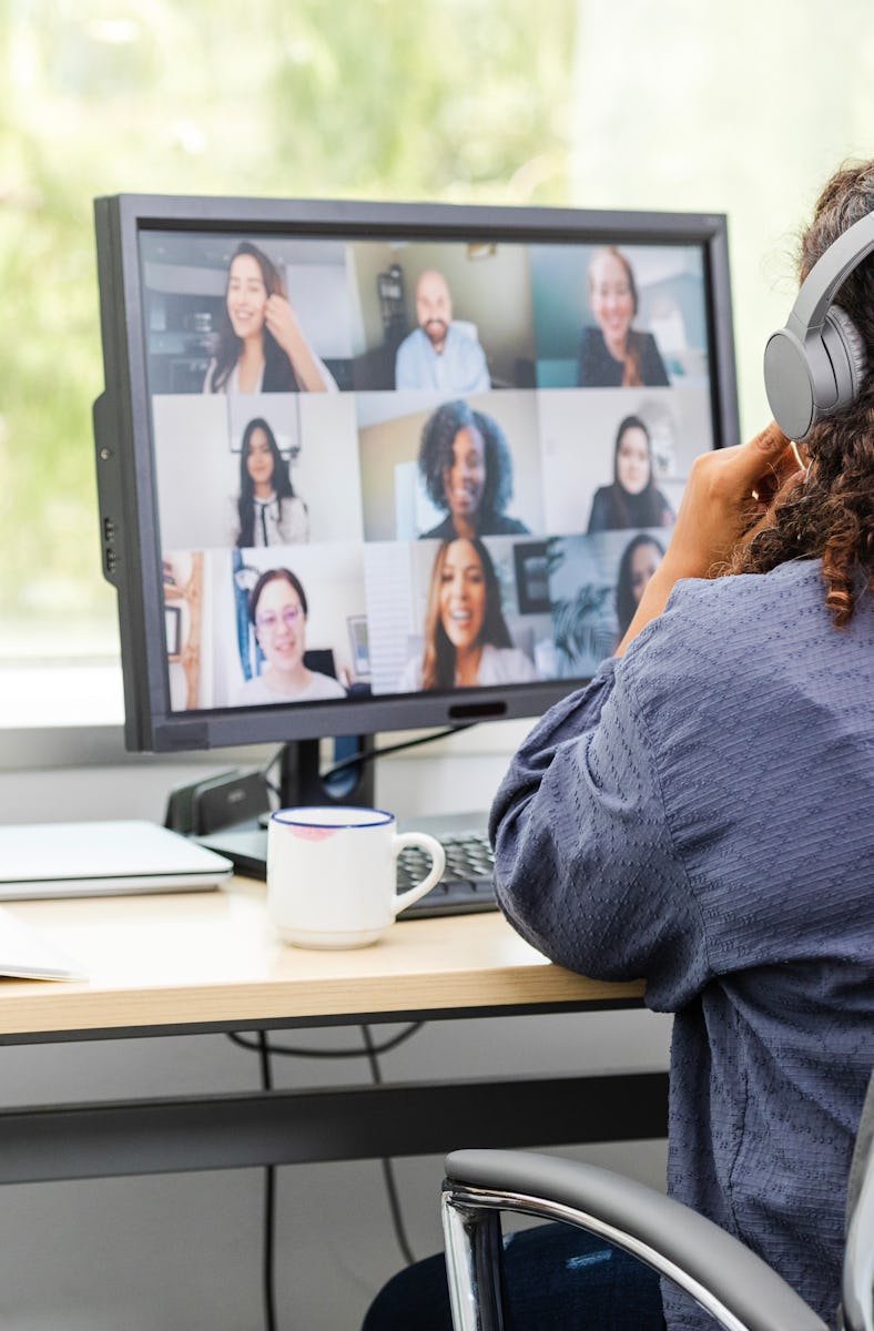 Telecommuting from her home office, the unrecognizable woman joins a virtual work meeting.