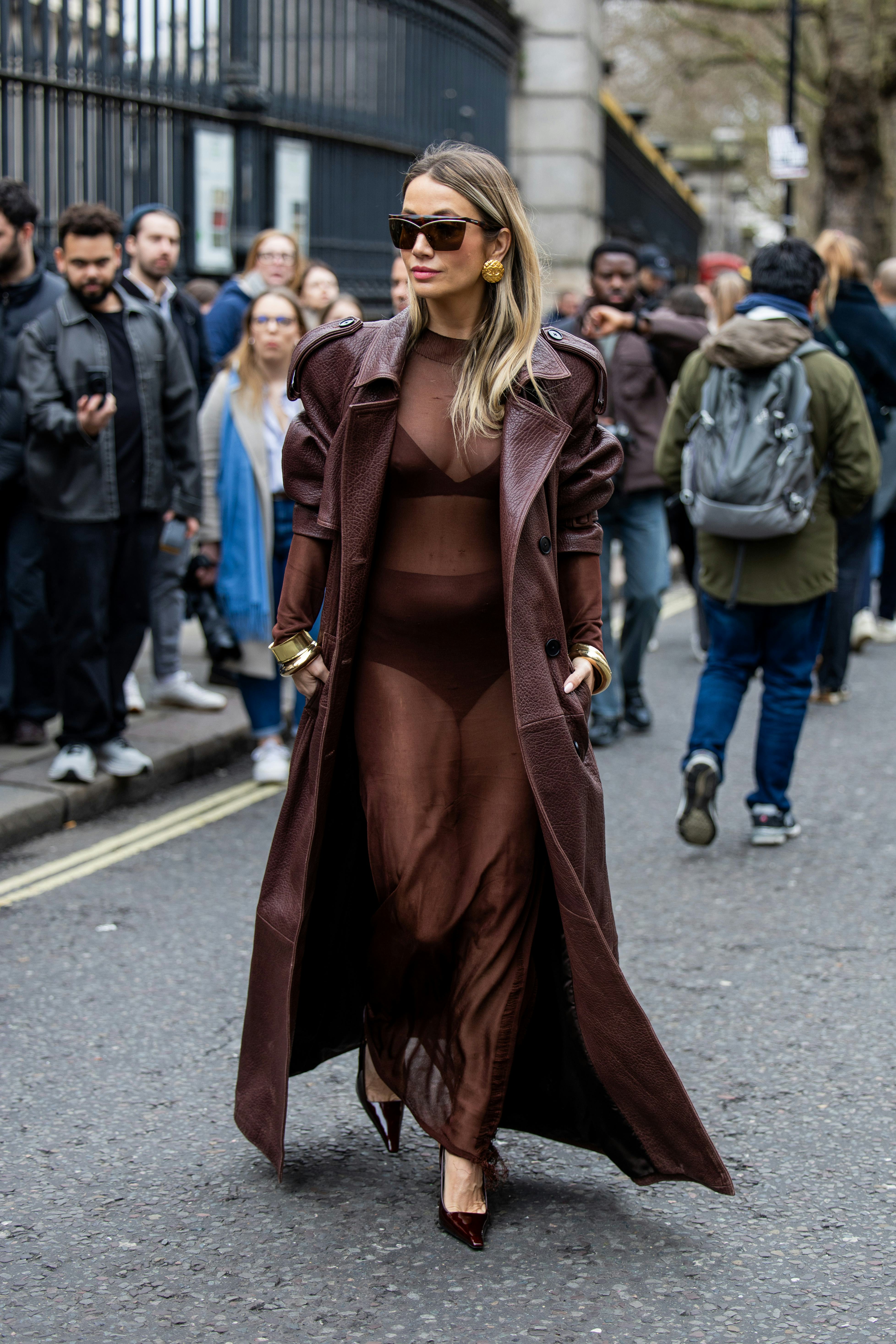 LONDON, ENGLAND - FEBRUARY 17: Nadia Phillips wears oversized brown coat, transparent dress, heels o&hellip;