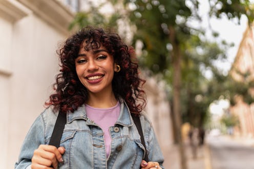 Portrait of young student woman waiting the bus outdoors