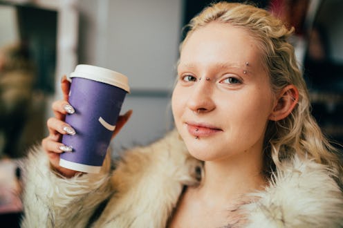 Amidst hustle and bustle of urban cafe, stylish albino woman, wearing shuggy coat, enjoying moment o...