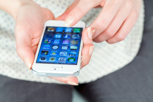 "Koszalin, Poland - September 27, 2012: Top view of woman hand holding an iPhone 5. Devices display ...