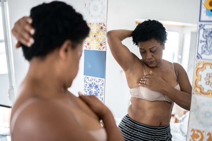 Mature woman doing self breast exam at home