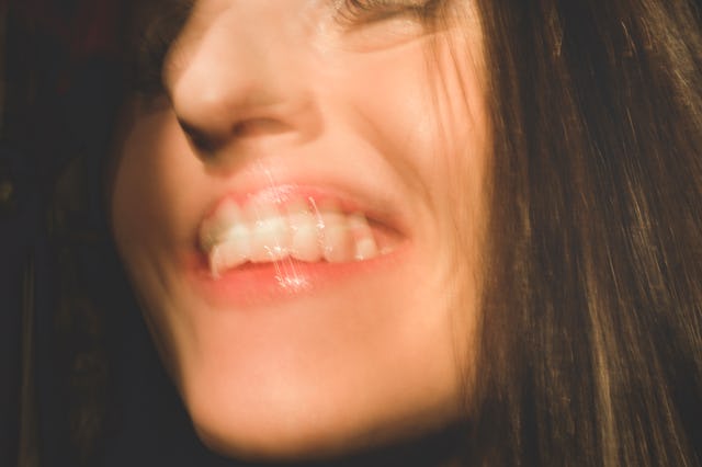 Happy woman: closeup of woman's face and mouth smiling. The candid woman's mouth is open with happin...