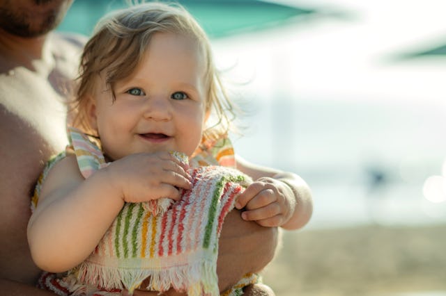 Baby girl and her father enjoying beach holidays