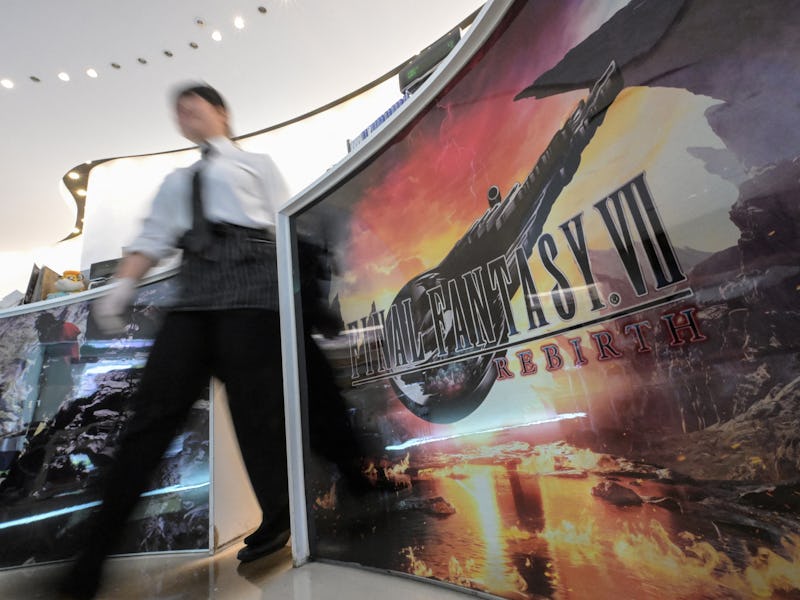 A member of staff walks past a display for 'Final Fantasy VII Rebirth', the latest release of the vi...