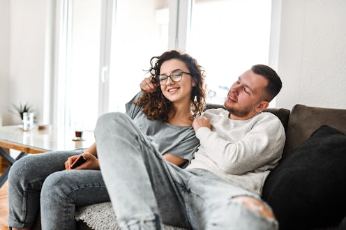 Male Embracing His Girlfriend During A Lazy Weekend On The Sofa