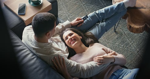 Above, house and couple on couch, smile and relationship with love, care and funny in living room. A...