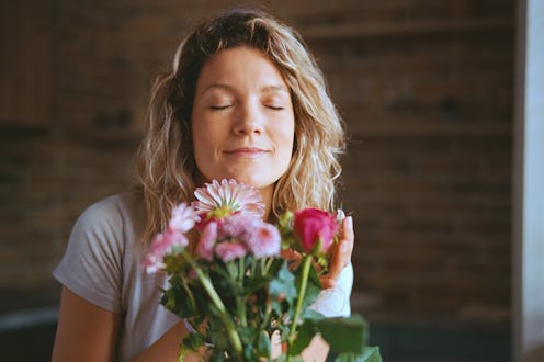 Smiling woman enjoying in the smell of fresh flowers with her eyes closed at home.
Leica M6, ektar ...