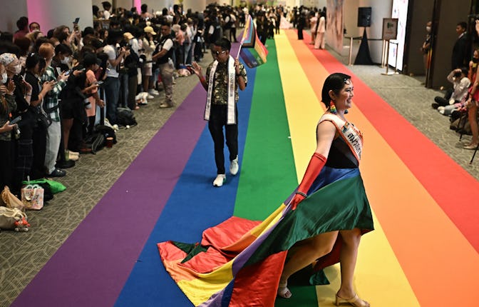 Members of the LGBTQ community walk on a rainbow carpet at a marriage registration event at Paragon ...