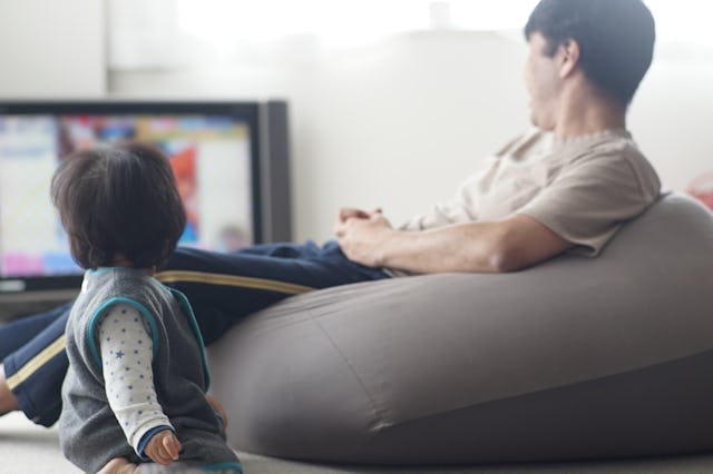 A dad plays video games as his baby watches. Singapore has instated new, stricter screen time guidel...