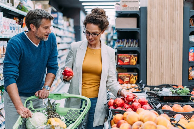 Shot of a lovely couple shopping in a grocery store. Happy couple buying fresh fruits and vegetables...