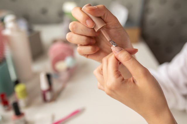 Close-up of young woman's hands applying nail polish