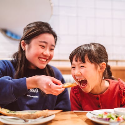 Two sisters playfully share a meal. A woman recently asked parents why they had children, and the answers are fascinating.