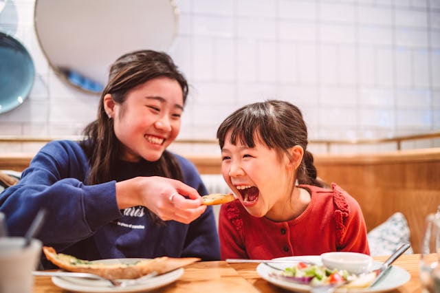 Two sisters playfully share a meal. A woman recently asked parents why they had children, and the an...