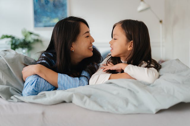 A mother and young daughter look lovingly into each other's eyes.