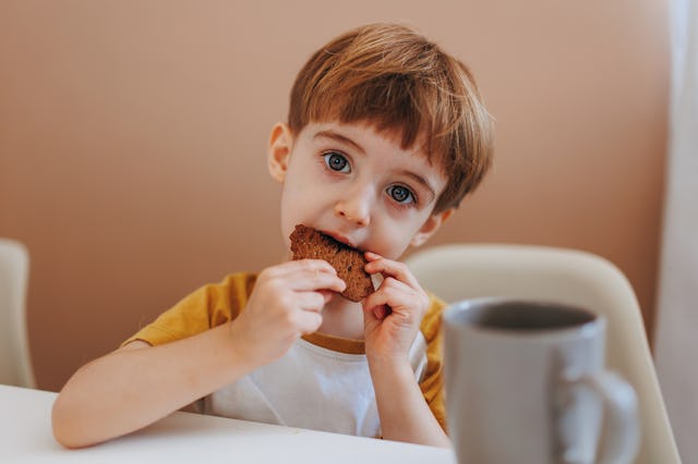 Boy eating cookie. Emotional overeating is associated with long term negative effects like unhealthy...