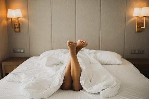 Female feet resting in bed. Wellbeing and leisure time in luxury hotel. Playful woman with sexy legs...