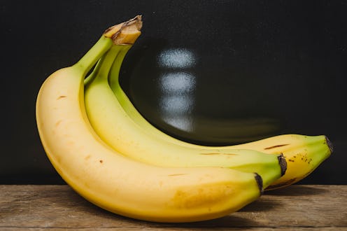 A photo of a few fresh bananas on a black background