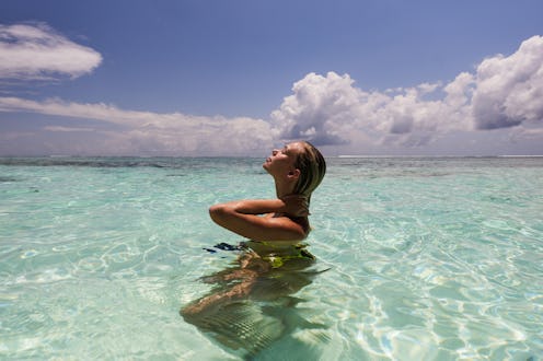 Young woman enjoying in the sun while spending a summer day in sea. Copy space.