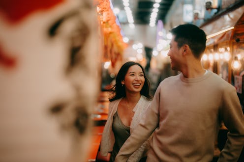Couple having a good time in narrow alleyway at night in Tokyo