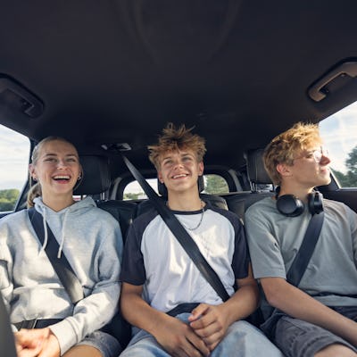 Three teenagers sit in the backseat of a car. Middle children, and those with siblings, scored higher in the categories of Honesty-Humility and Agreeableness.