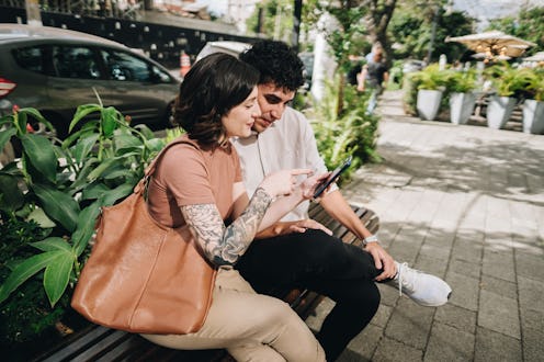 Young woman showing mobile phone to boyfriend in the city