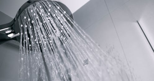Low angle view of water flowing from shower head in bathroom.