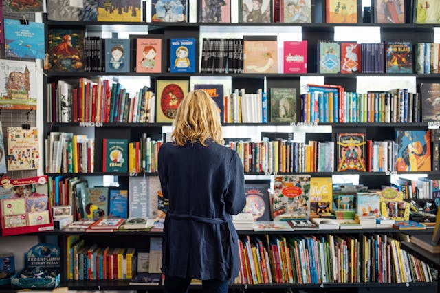 Rear view of a woman looking at books at a bookshop, in a story about the most anticipated new books...