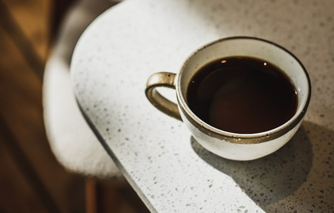 Cafe culture, long black or americano coffee. Morning daily routine. Cup with hot beverage in sunshi...