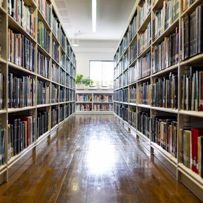 Empty hall full of books at the library - education concepts